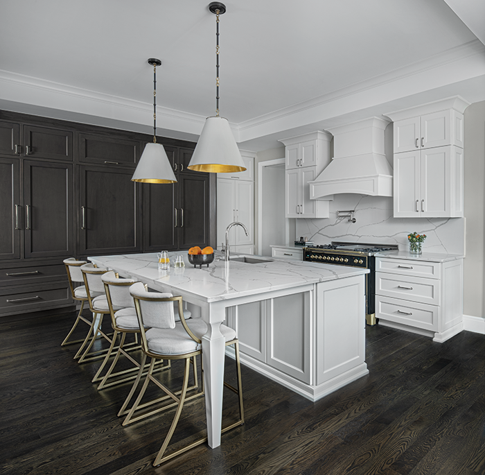 Uniquely patterned quartz countertops, comfortable Ballard Designs stools, and Newport Brass hardware, among other elements, make this kitchen super chic.