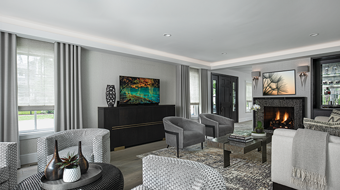 LAYERED APPEAL - The formal living room was kept in its original location, but the fireplace was redesigned. Anton says the homeowners wanted to integrate a television in the room so she had Architectural Kitchens design a custom pop-up that could be disguised when not in use. 