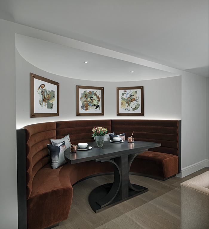 An existing curved wall in the lower level was given a new cozy seating area, perfect for watching television, playing cards, or having a cocktail from the nearby bar, says designer Ann-Marie Anton. 