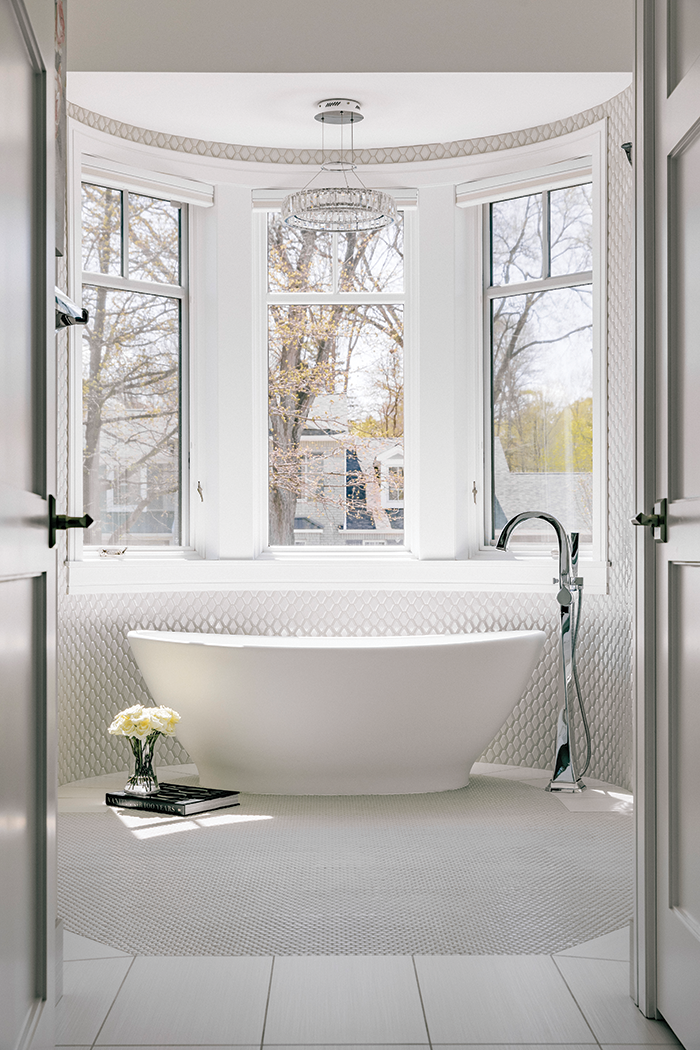 A freestanding tub in a rounded bay is a focal point in the primary bath.